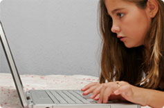 young girl staring at laptop screen